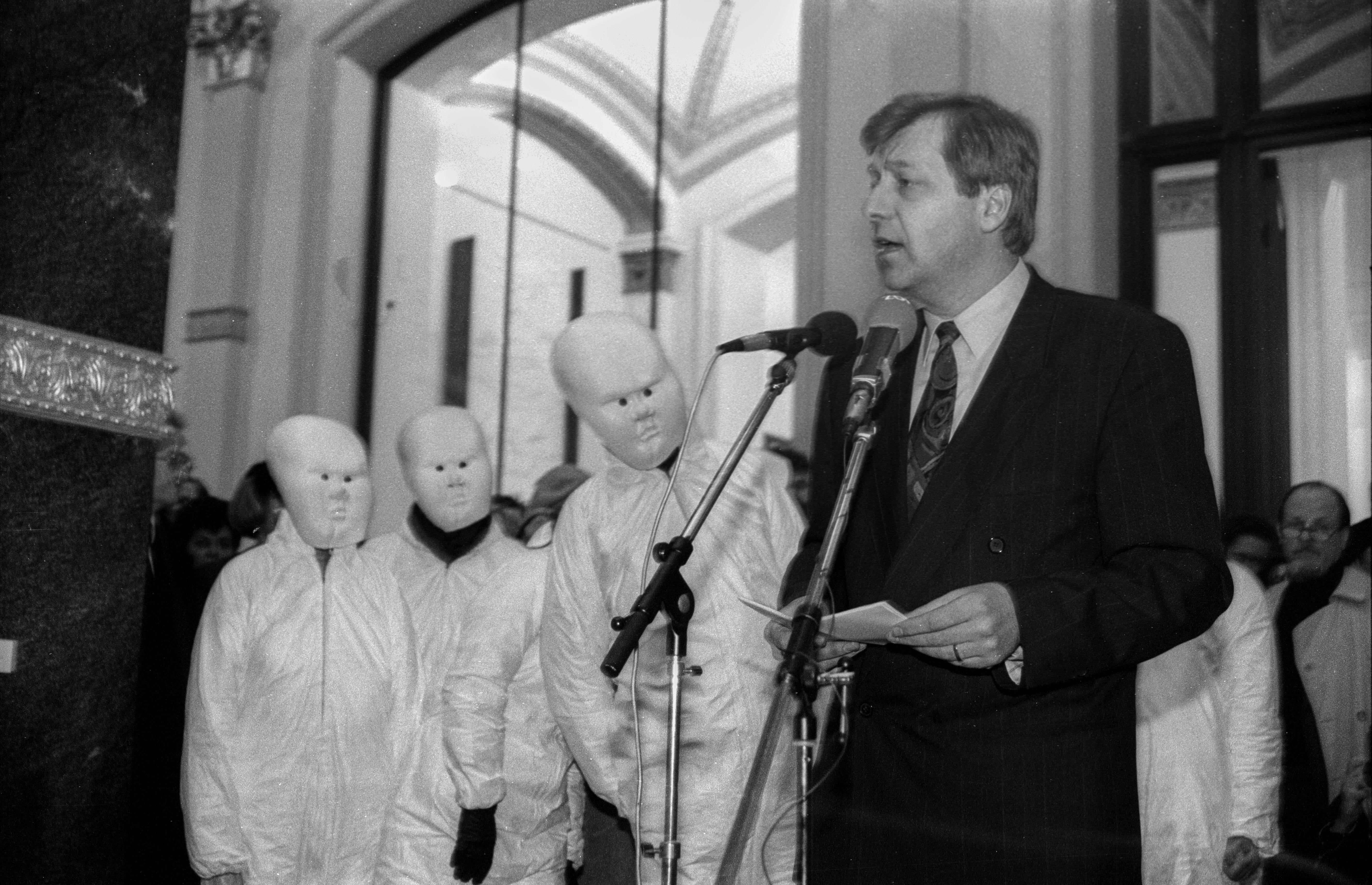 Das Bild zeigt Eberhard Diepgen am 19.4.1991 bei einer Ansprache in der Kunsthochschule in Berlin Weissensee und drei mit weissen Masken und Umhängen maskierte Studierende