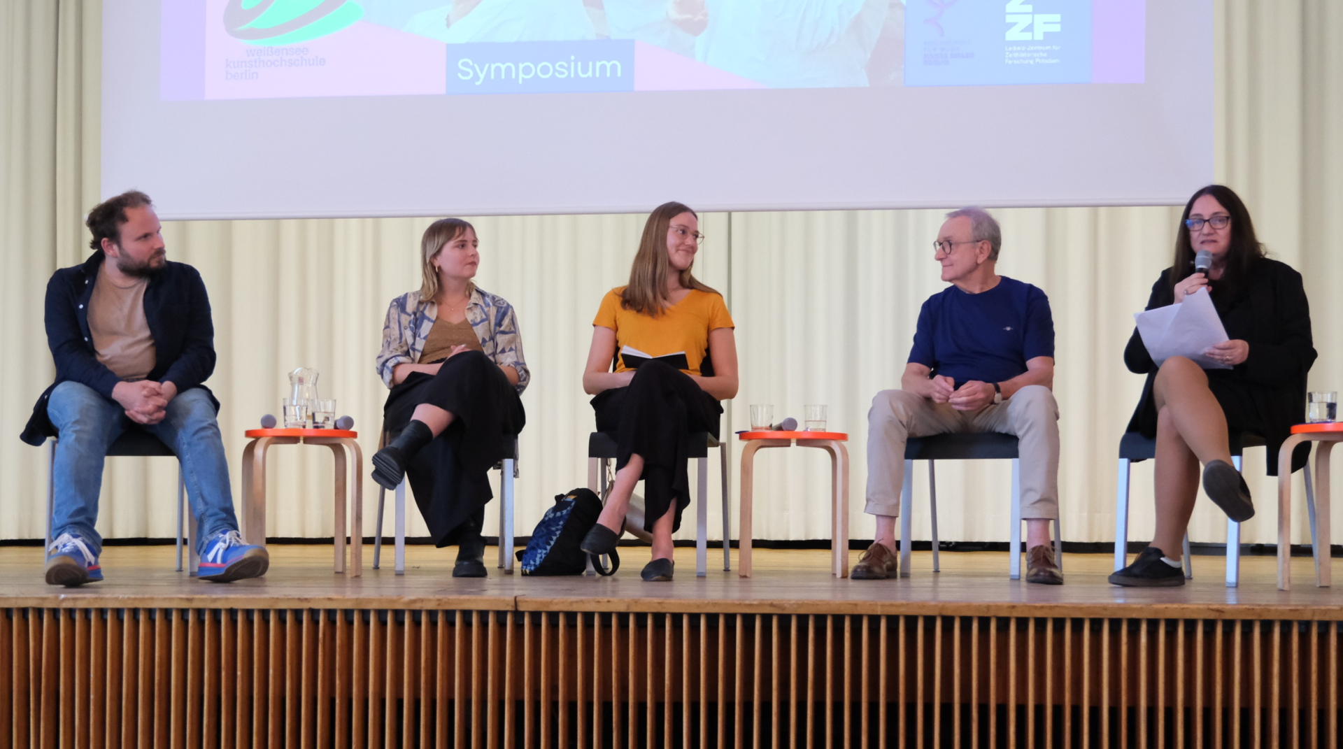 Das Fotomtzeigt die fünf Teilnehmer*innen des dritten Panels des Symposiums "Kultur im Umbruch" am 4.6.2026 sitzend auf dem Podium.