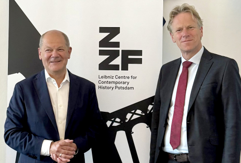 Bundeskanzler a.D. Olaf Scholz und ZZF-Direktor Frank Bösch vor einem Banner mit dem Logo des ZZF.