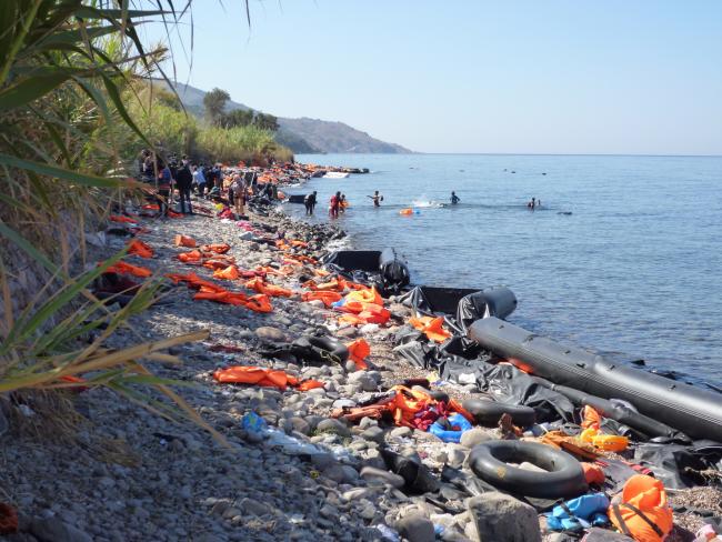 Foto: Rosa-Maria Rinkl: Blick auf die Nordküste von Lesbos zwischen den Ortschaften Molivos und Sykaminia. Der Küstenstreifen ist voll von Schwimmwesten und Flüchtlingsbooten. Die Aufnahme stammt vom September 2015, CC-BY-SA-4.0
