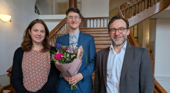 Agnes Bauer in der Fotomitte nach der erfolgreichen Verteidigung ihrer Dissertation mit Blumenstrauss und Prüfer*innen