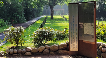 Blick auf den Flüchtlingsfriedhof der Kriegsgräberstätte in Oksbøl in Dänemark vom Gebäude der Dauerausstellung aus. Im Vordergrund istv eine Tafel der Dauerausstellung zu sehen, die im Julki 2026 eröffnet wurde..