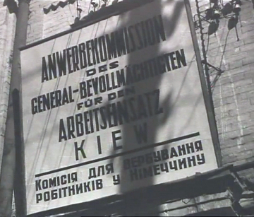 Schwarz-Weiß-Aufnahme eines Schildes am Sitz der Kiewer Anwerbekommission (in Deutsch und Ukrainisch), abgebildet circa 1941/42.