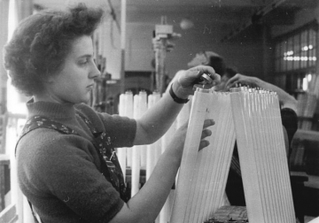 Eine Arbeiterin in einem Glühlampenwerk in der DDR bei der Arbeit.