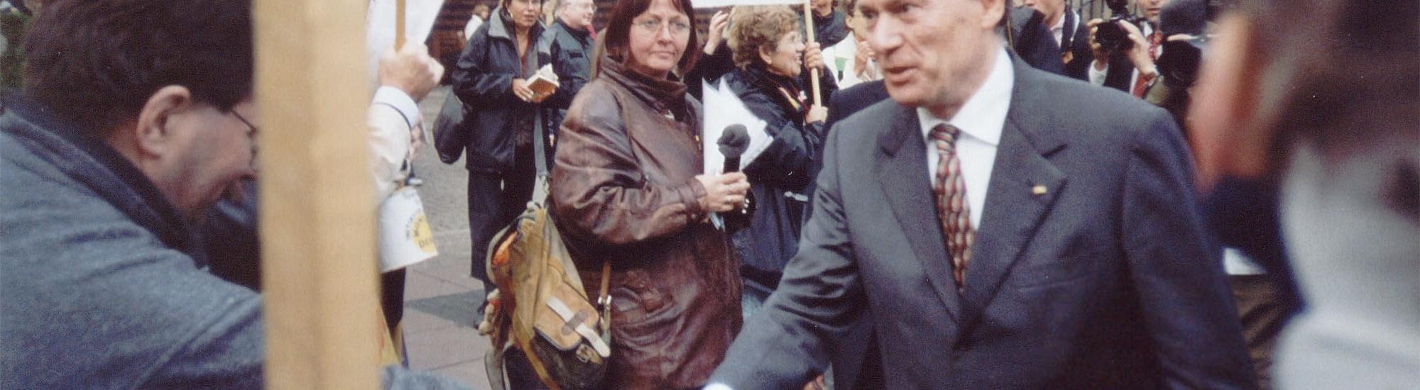 Der damalige Bundespräsident Horst Köhler schüttelt die Hand eines Demonstranten.