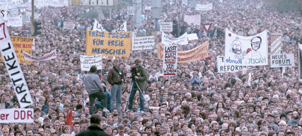 Foto einer großen Menschenmenge bei einer Demonstration am 4. November 1989. Viele der Menschen tragen Plakate und Transparente.